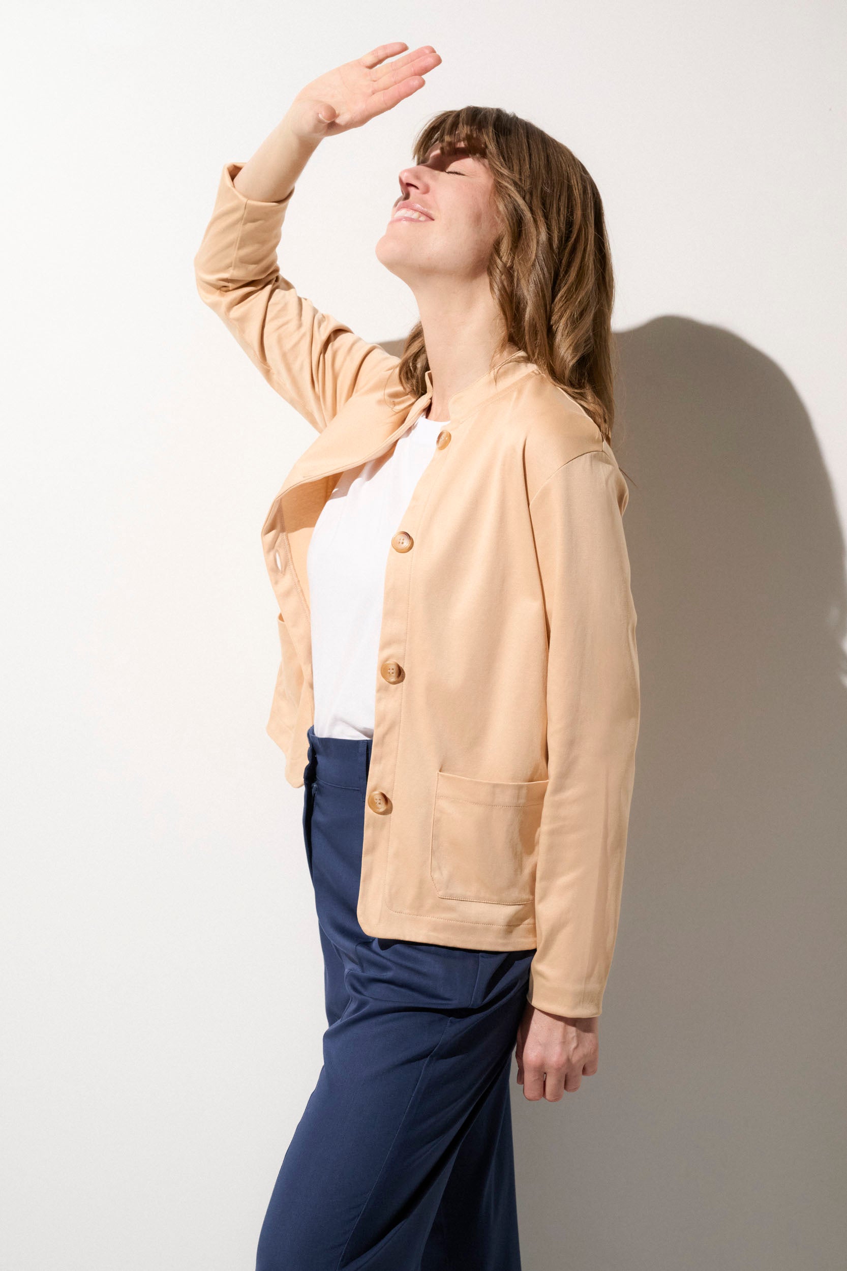 Cardigan anti-UV beige UPF50+ pour femme, élégant et léger, idéal pour un café ensoleillé ou une sortie en ville.