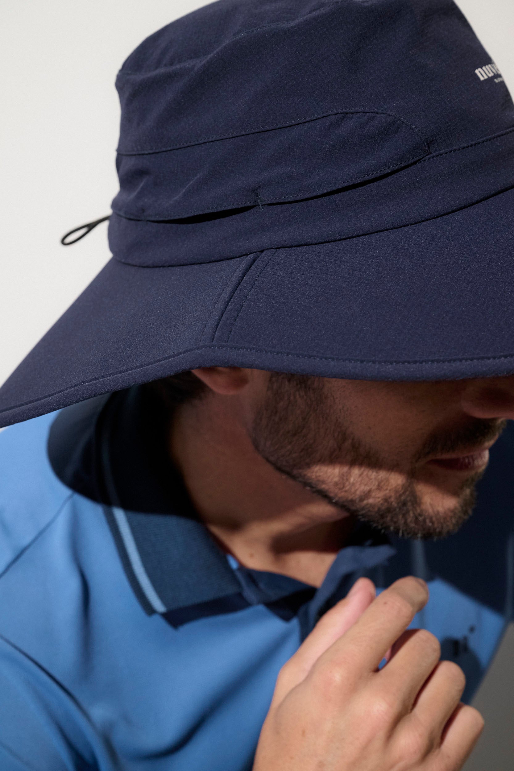 Chapeau anti-UV bleu pour homme, léger et respirant, offrant une protection solaire UPF 50+ lors de la pratique du golf.