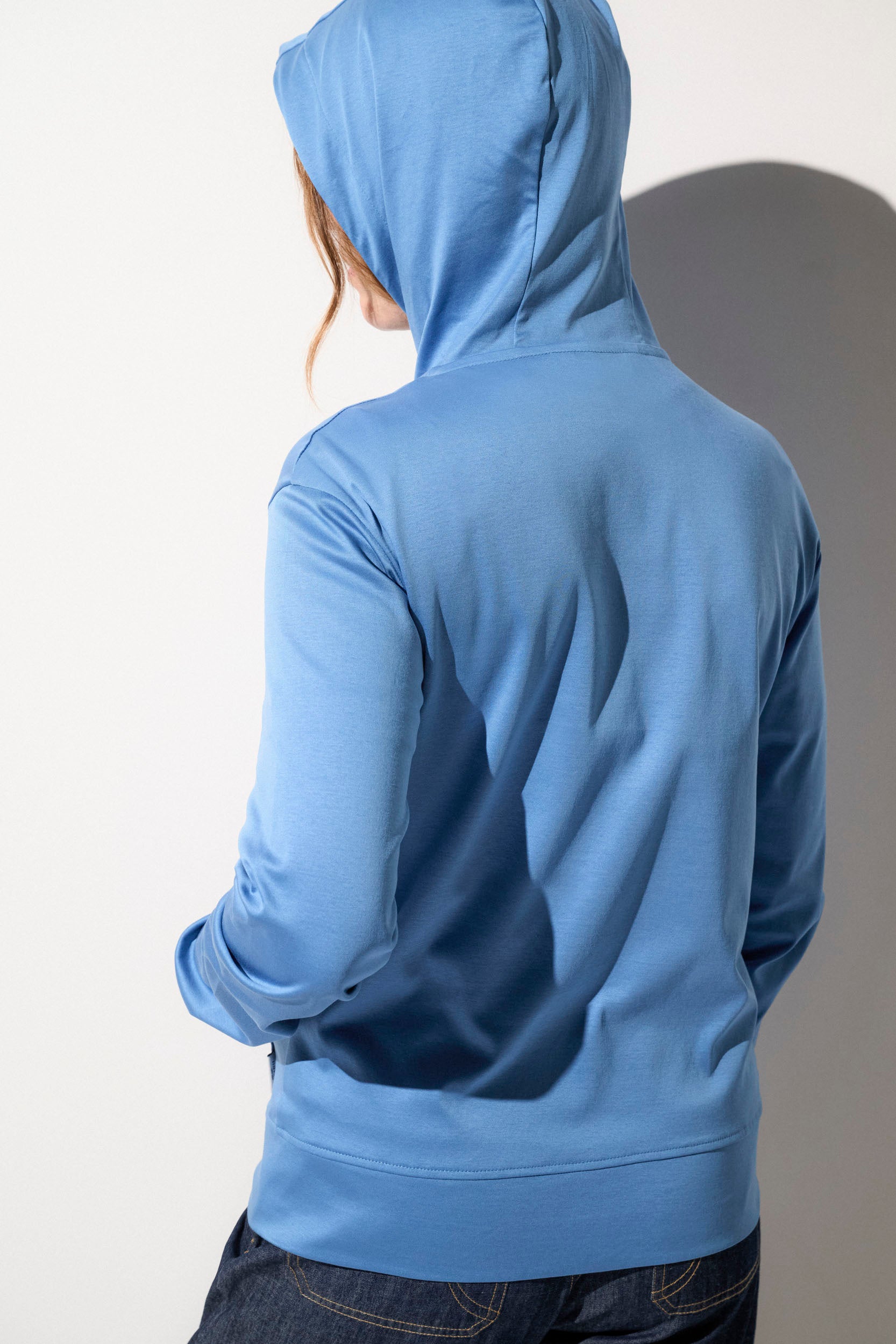 Sweat-shirt anti-UV bleu à capuche pour femme, offrant confort et protection solaire UPF50+ lors des activités en plein air.