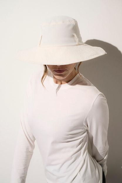 Chapeau anti-UV blanc UPF50+ porté par une femme, idéal pour une protection solaire élégante au quotidien.