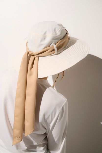 Chapeau anti-UV beige avec ruban pour femme, léger et élégant, offrant une protection solaire UPF50+.