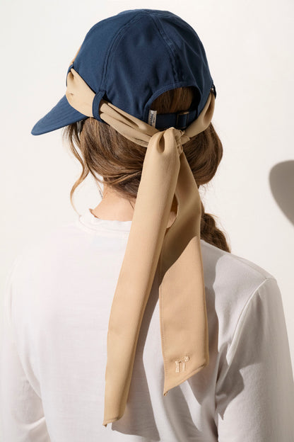 Casquette anti-UV bleue avec un nœud beige, idéale pour femme, offrant une protection solaire UPF50+ au quotidien.