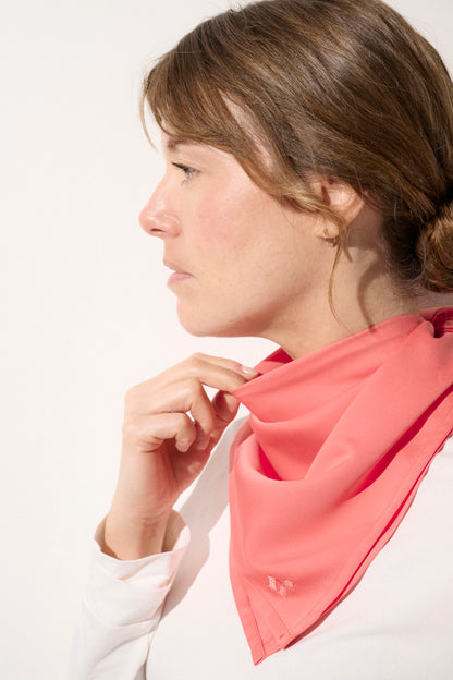 Foulard anti-UV rose pour femme, protection solaire UPF50+, porté avec élégance autour du cou.