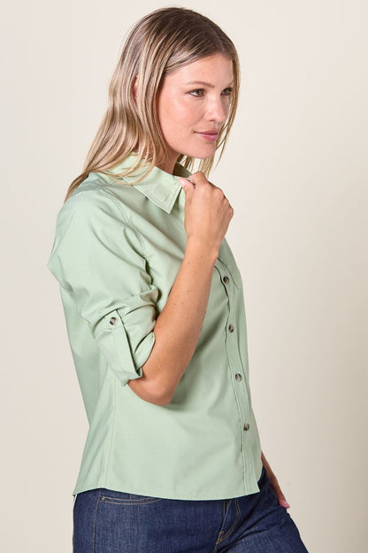 Chemise anti-UV verte pour femme, élégante et légère, offrant protection solaire UPF50+ pour des journées en plein air.