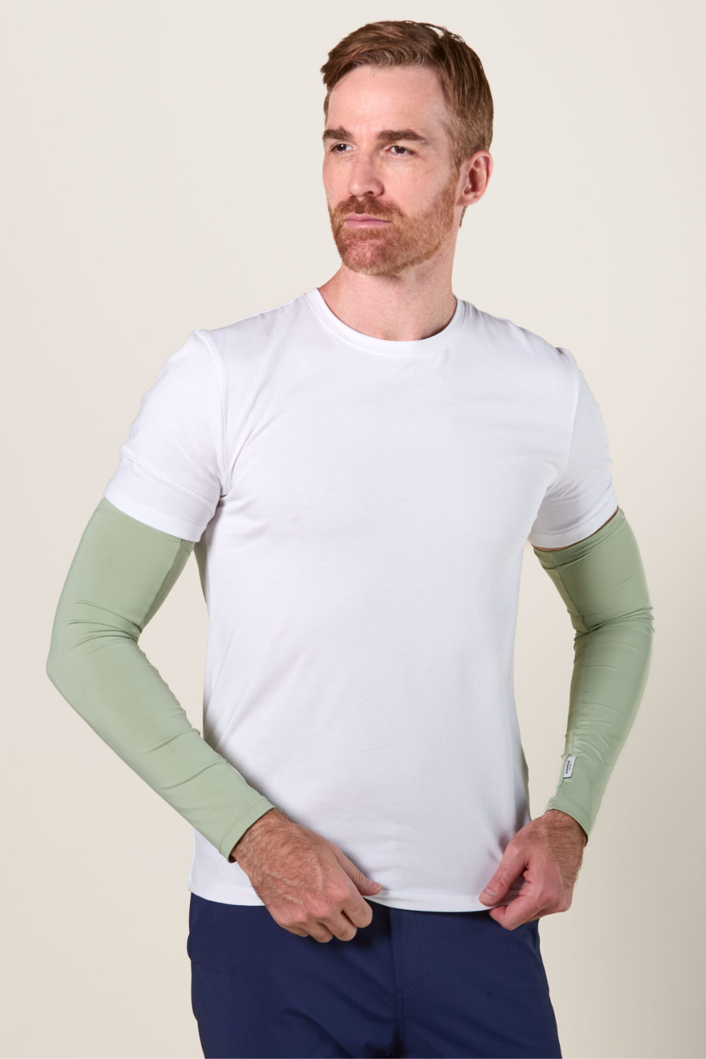 Manches anti-UV vertes UPF 50+ pour homme, portées avec un t-shirt blanc, idéales pour protection solaire.