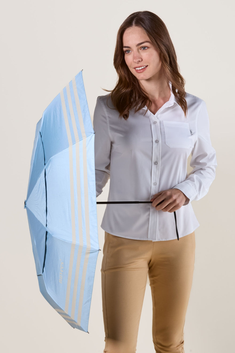 Ombrelle anti-UV bleue UPF50+ tenue par une femme, parfaite pour se protéger du soleil lors de ses activités extérieures.