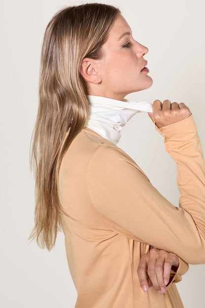 Femme portant un tour de cou anti-UV blanc UPF50+, léger et respirant, pour une protection solaire élégante.