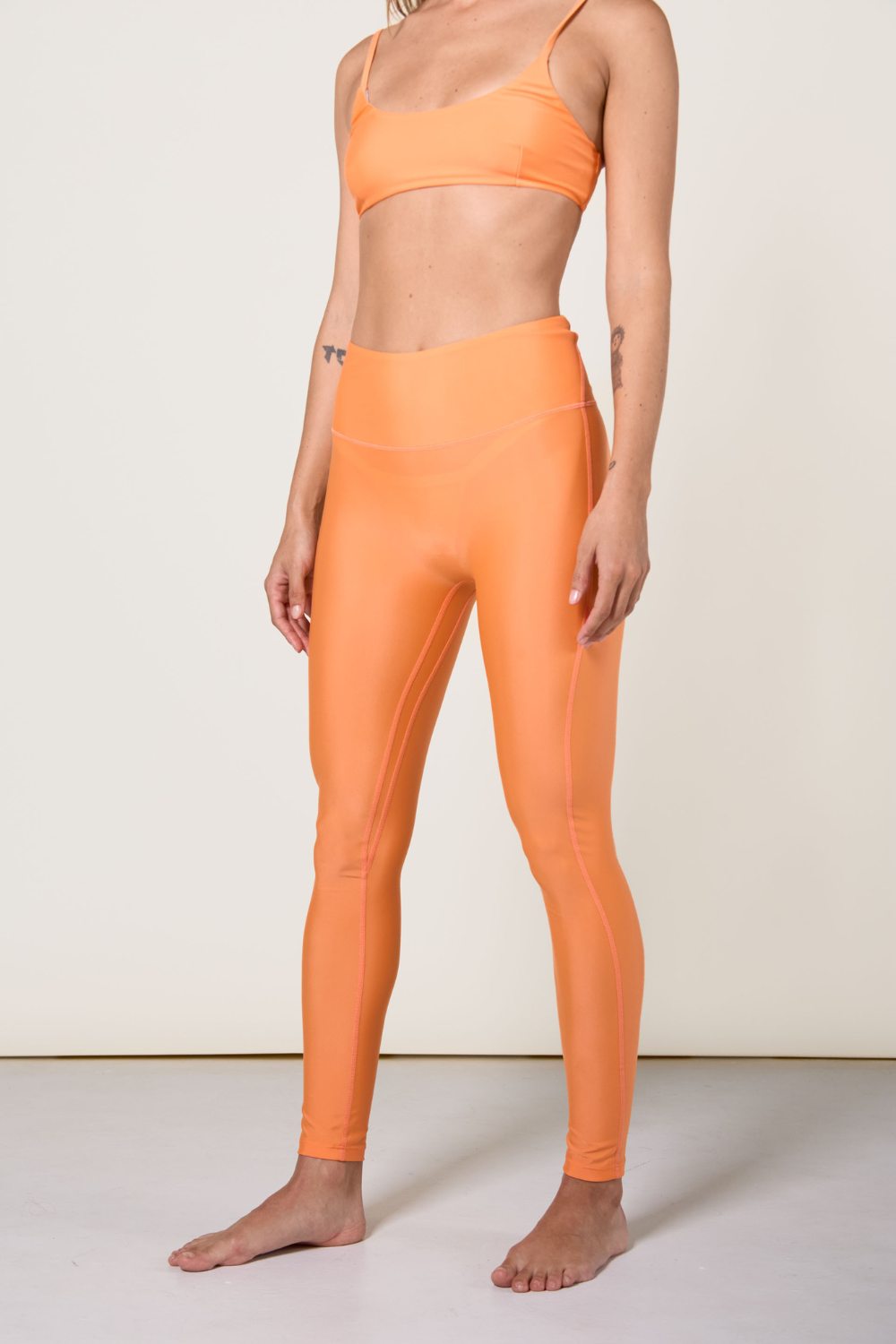 Legging de bain anti-UV orange pour femme, certifié UPF 50+, idéal pour les activités aquatiques et la plage.