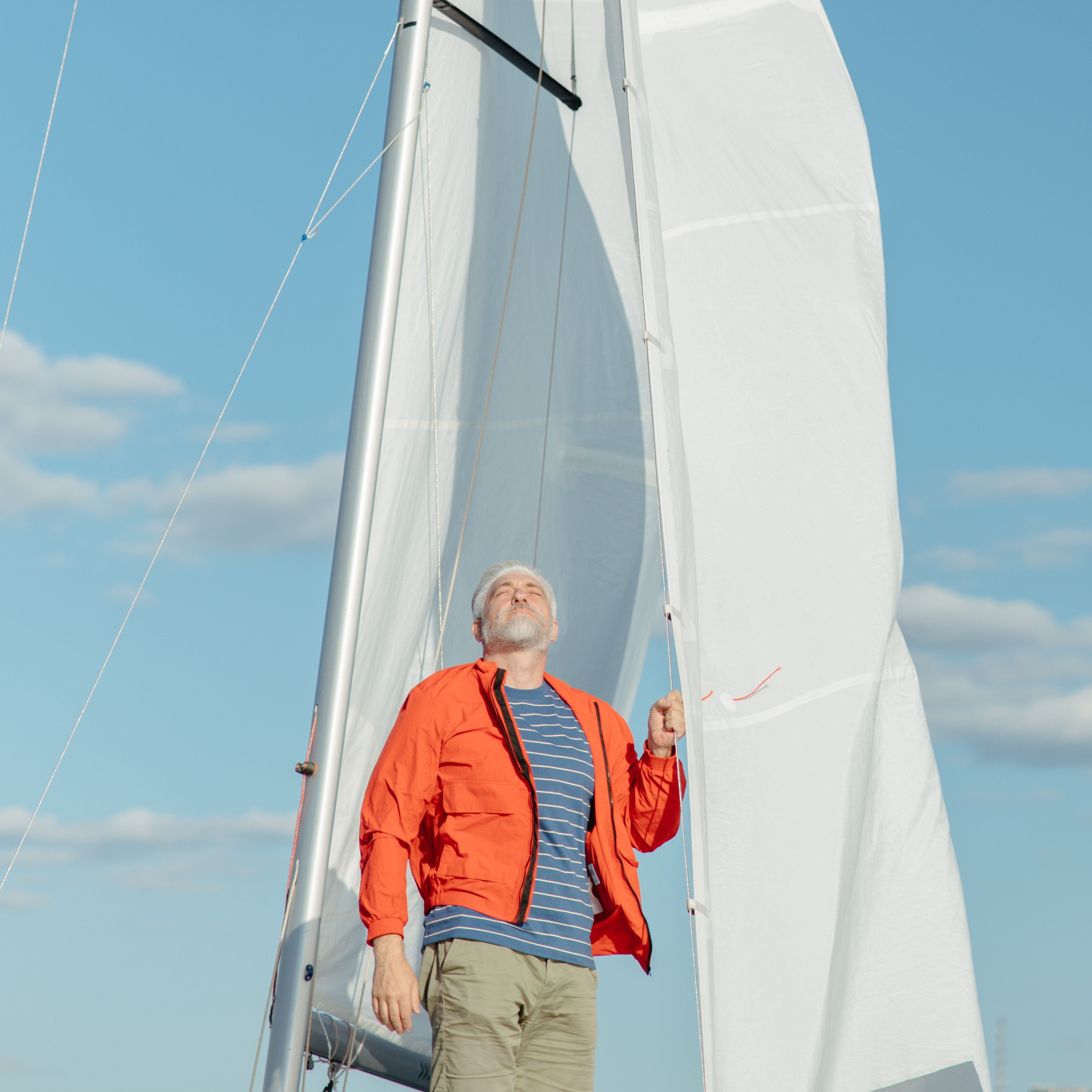 Homme profitant du soleil sur un voilier, protégé par des vêtements anti-UV UPF 50+